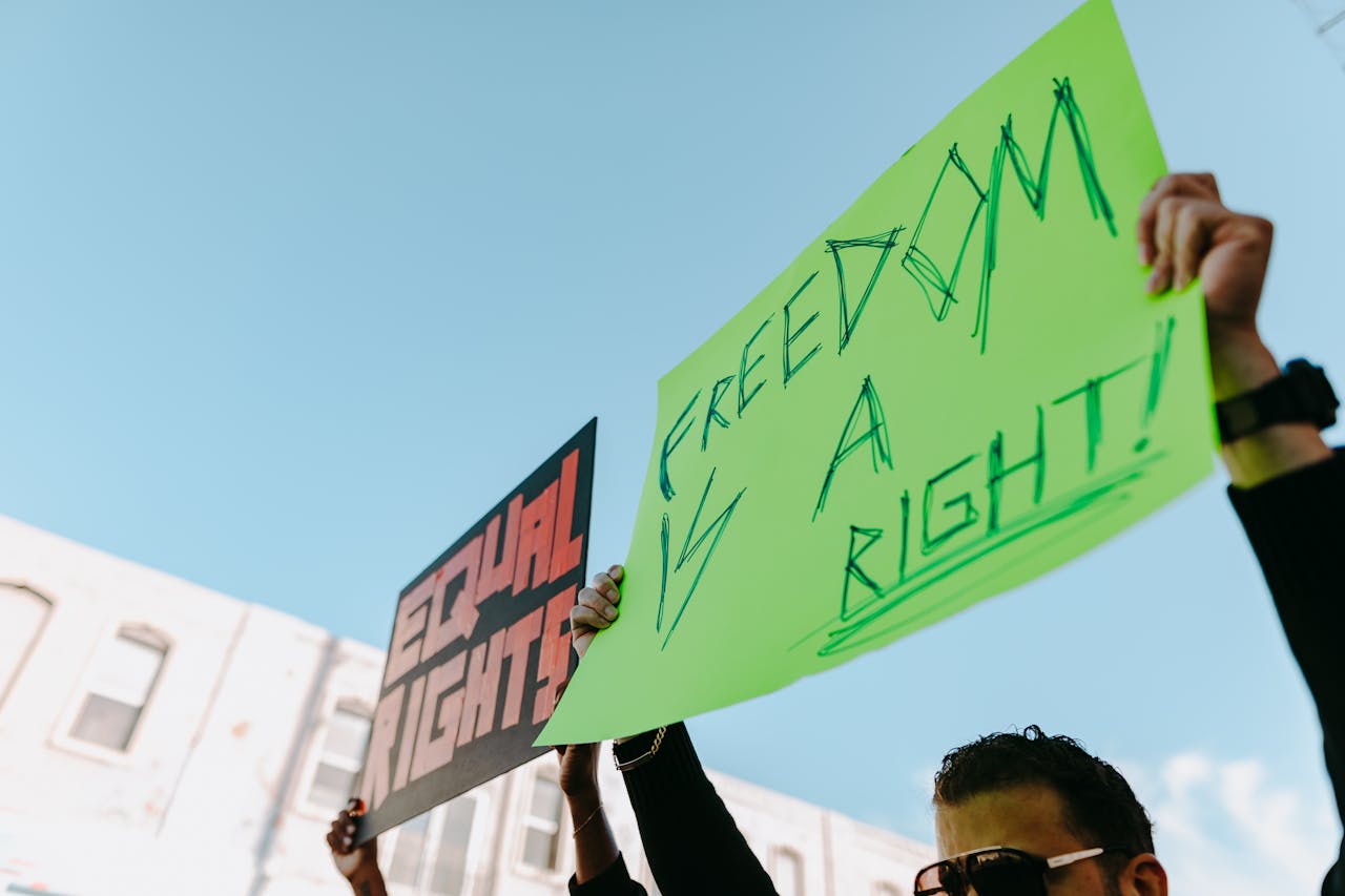 Protesters in a rally holding signs for equal rights and freedom.
