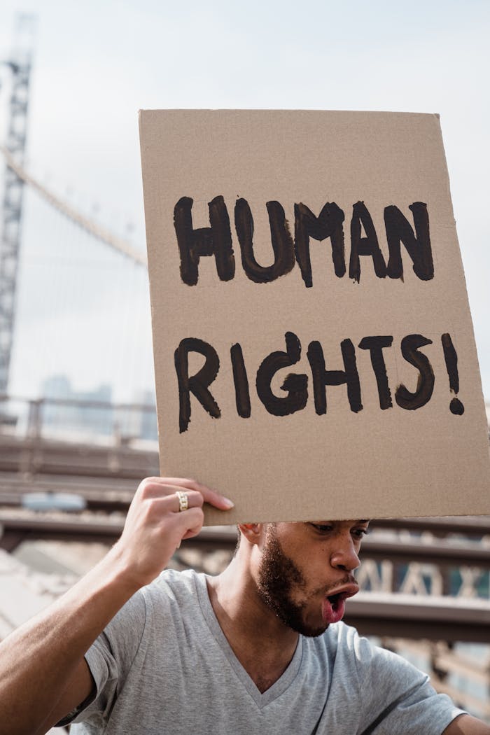 Person passionately protesting with a 'Human Rights' sign outdoors.